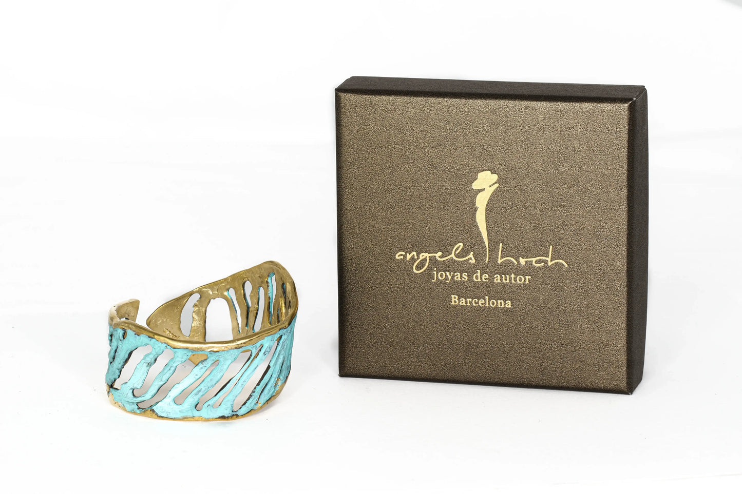 Turquoise cuff bracelet with gold-tone cutout wave design, shown with box