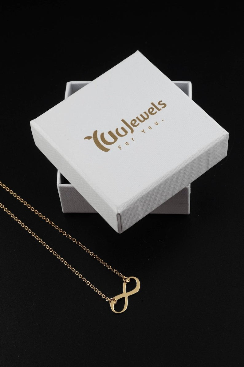 Gold infinity pendant necklace with fine chain on white gift box