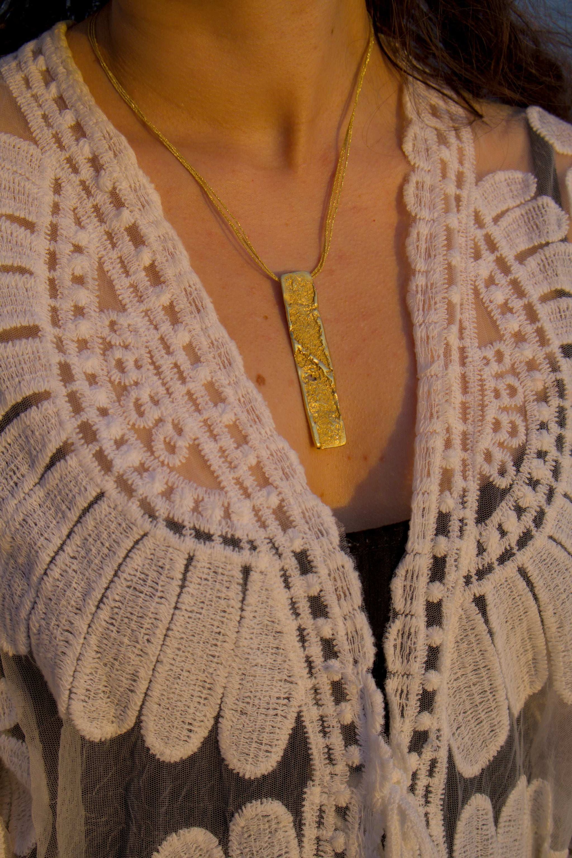 18K gold strata pendant necklace worn with textured rectangular pendant on chain