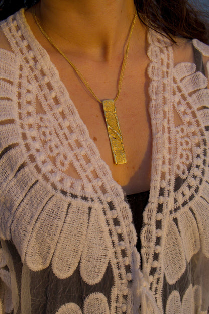 18K gold strata pendant necklace worn with textured rectangular pendant on chain