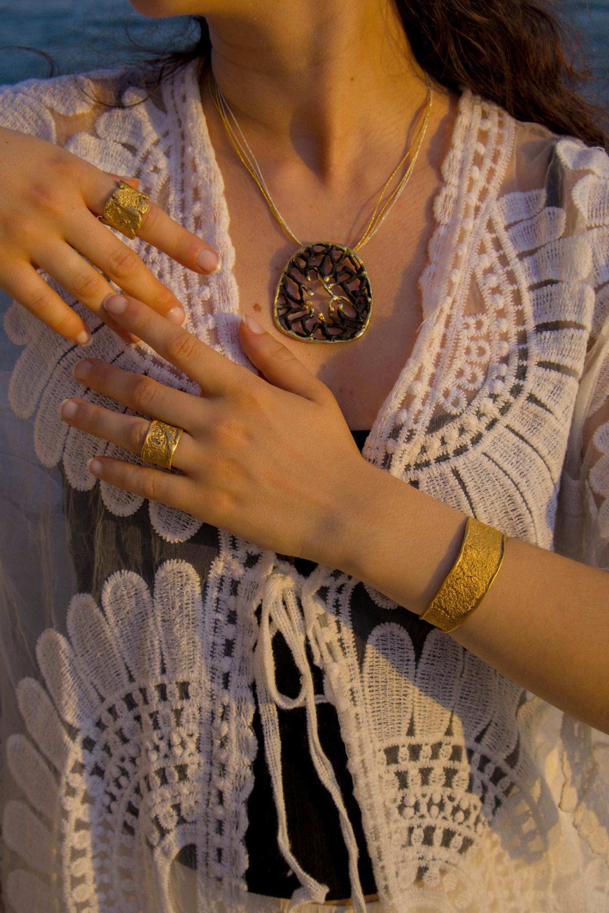 18K Terra Viva ring on hand, textured gold wide band with organic knotted look