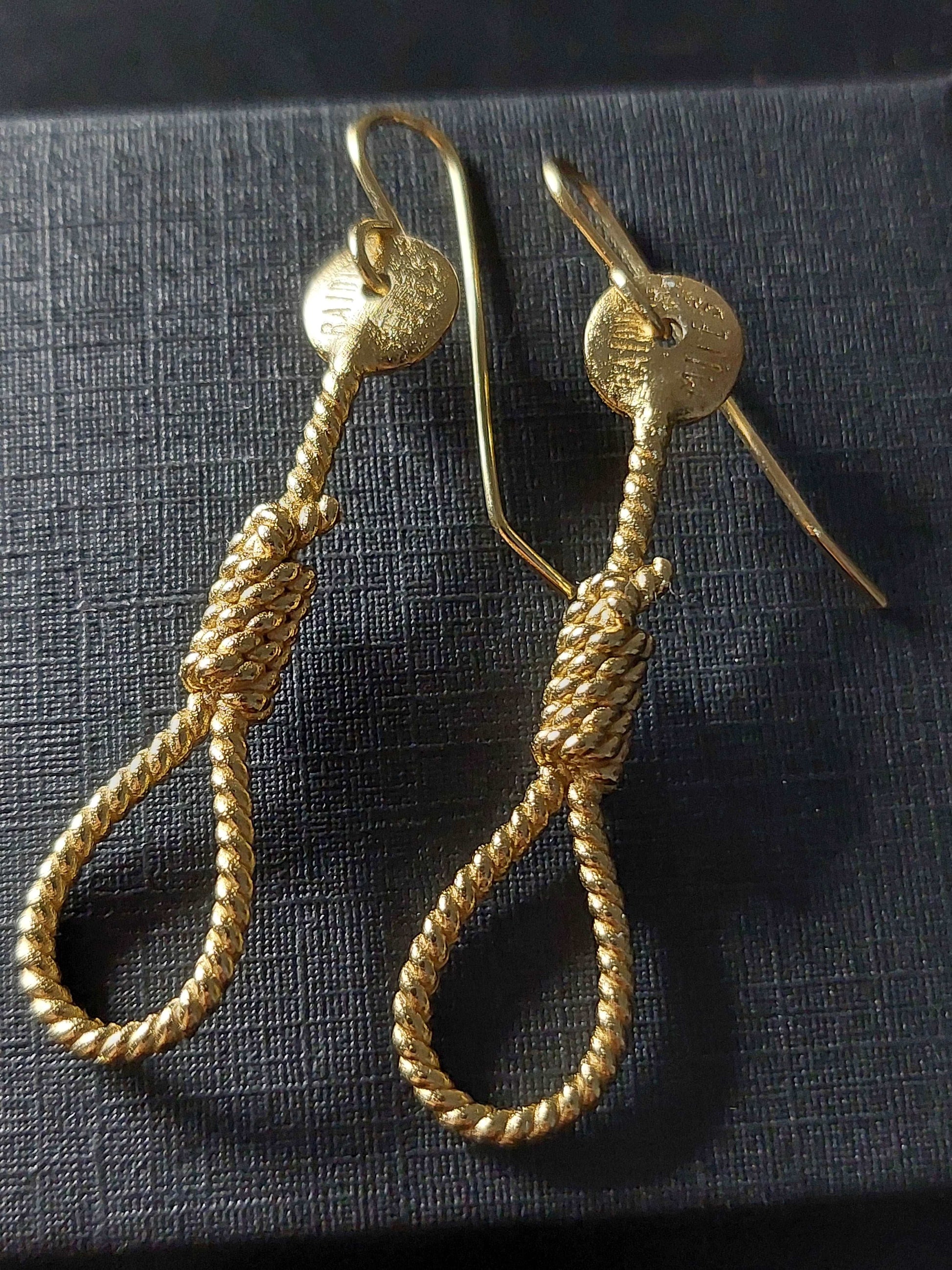 Gold rope-shaped dangle earrings with hook backs, textured round tops and coil teardrop drops