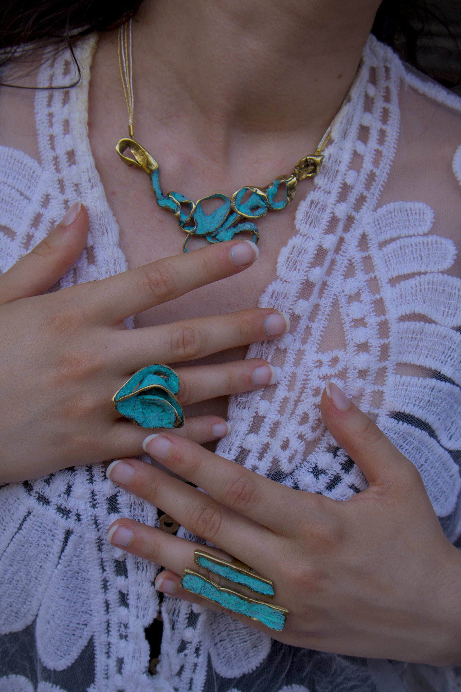 Turquoise enamel ring with gold-tone band, worn on finger