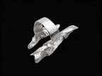 Silver open wave ring with smooth curved band and jagged textured edges.