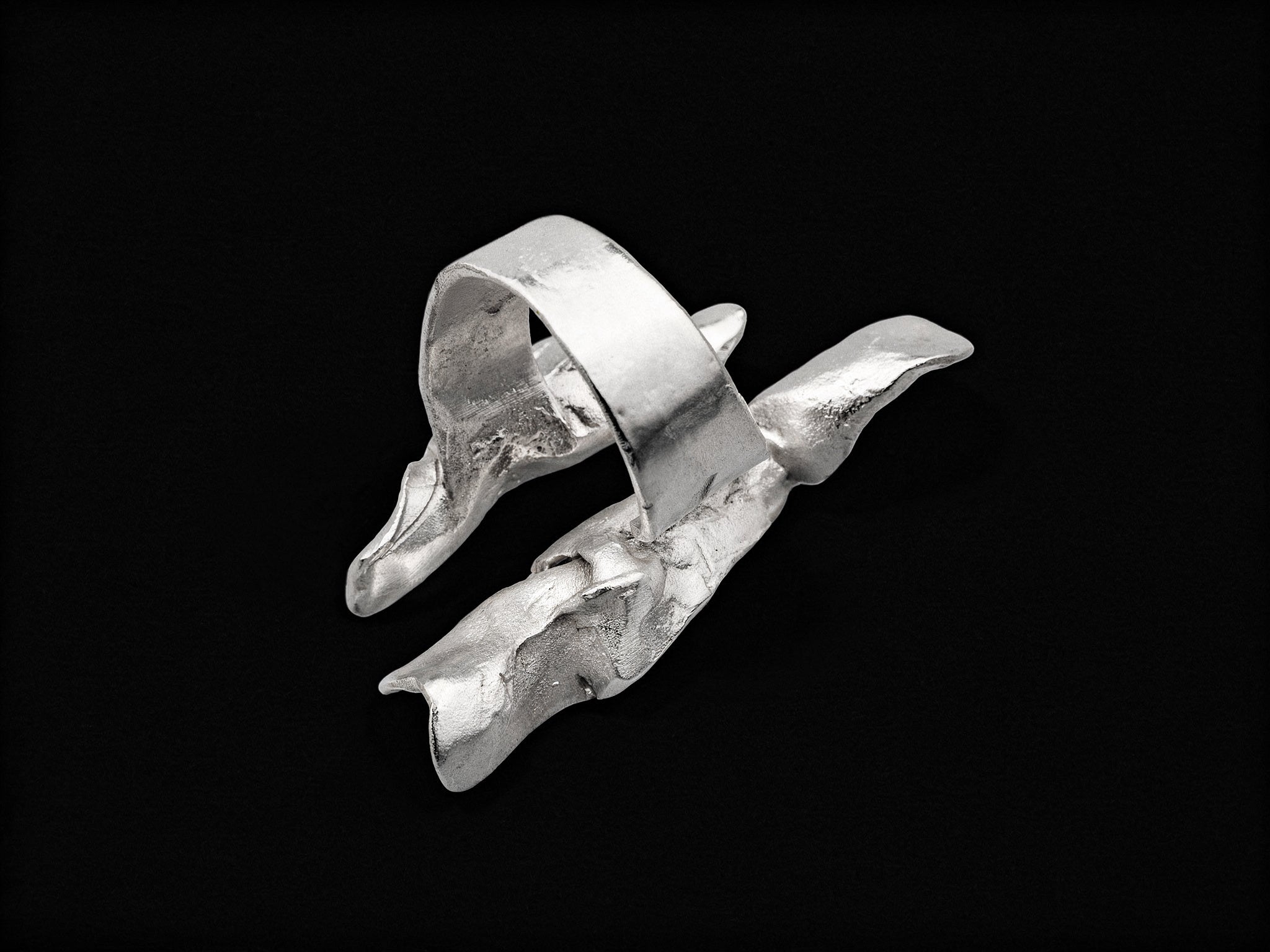 Silver open wave ring with smooth curved band and jagged textured edges.
