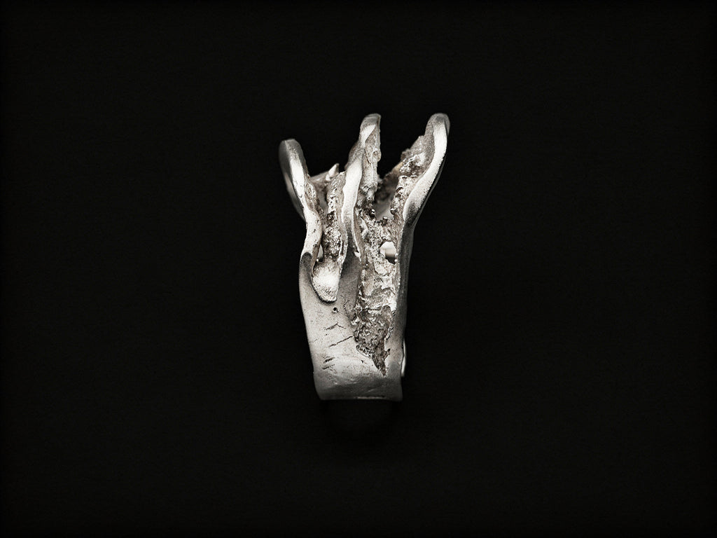 Silver sculpted ring with tall jagged centerpiece and textured metal band