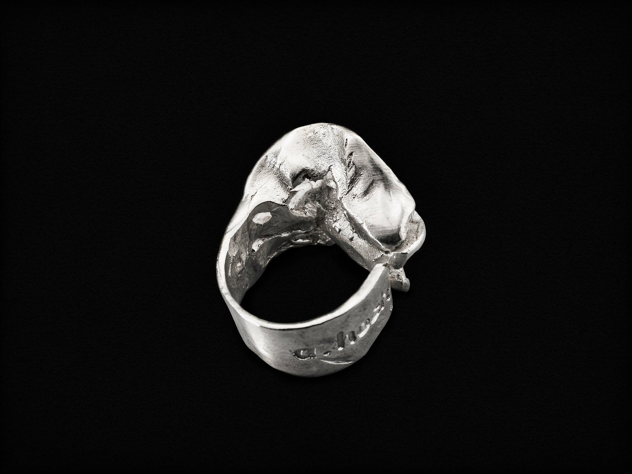 Silver sculpted ring angled view with claw-like textured centerpiece