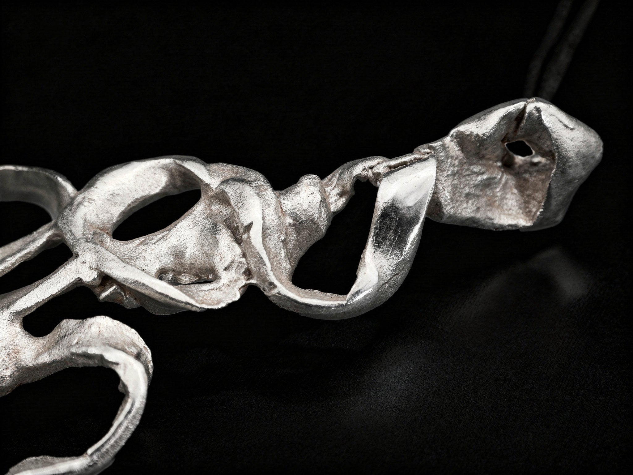Silver coral-style pendant segment with interlocking open rings and textured surface