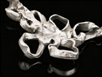 Silver coral-style pendant centerpiece with open ring loops and hammered texture