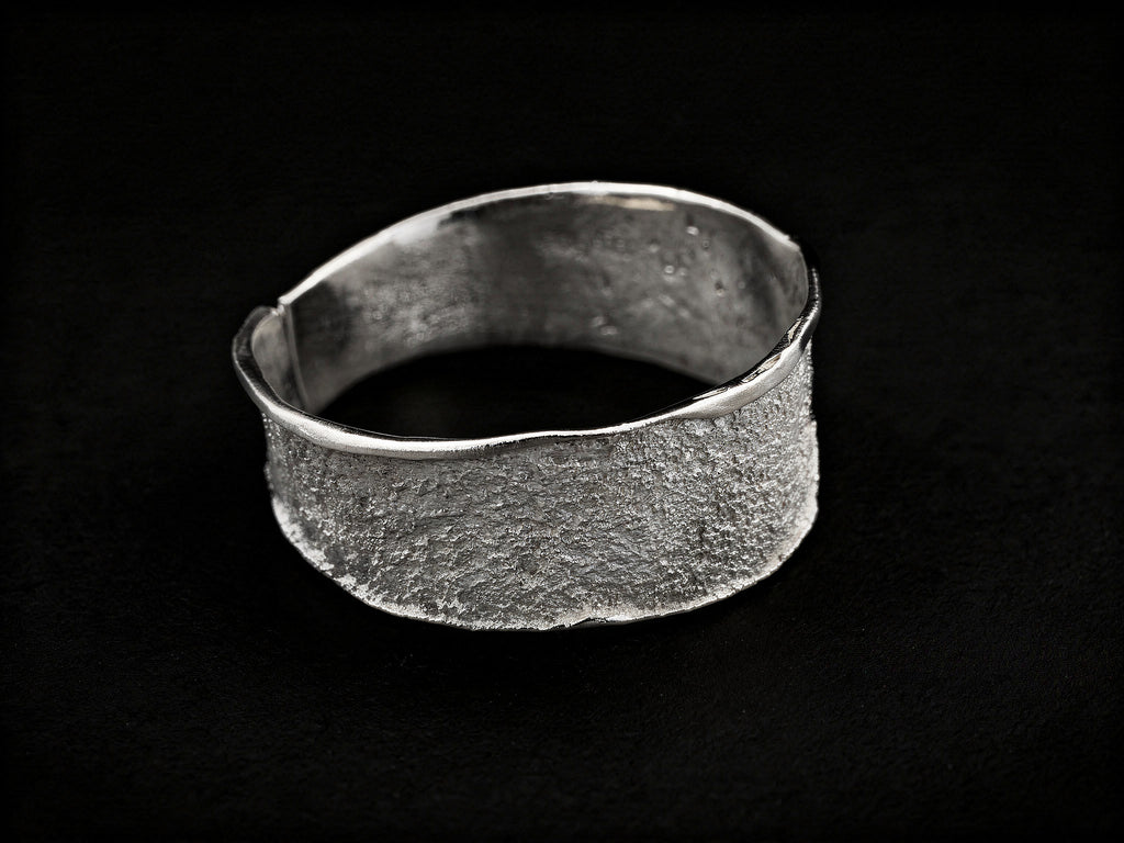 Silver textured cuff bracelet with wide band and smooth open-ended interior
