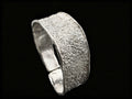 Silver textured cuff bracelet, side view showing thick band and inner rim