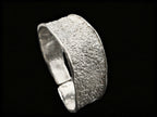 Silver textured cuff bracelet, side view showing thick band and inner rim
