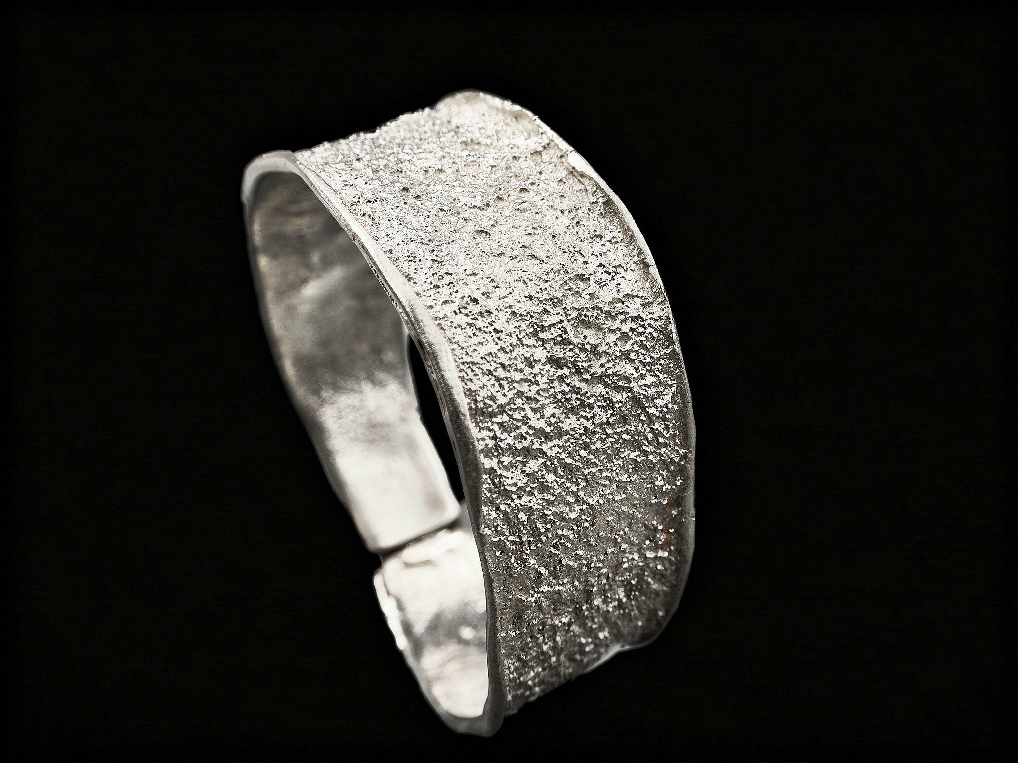 Silver textured cuff bracelet, side view showing thick band and inner rim