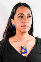Fragments earrings with blue square studs and drop posts, on earlobe