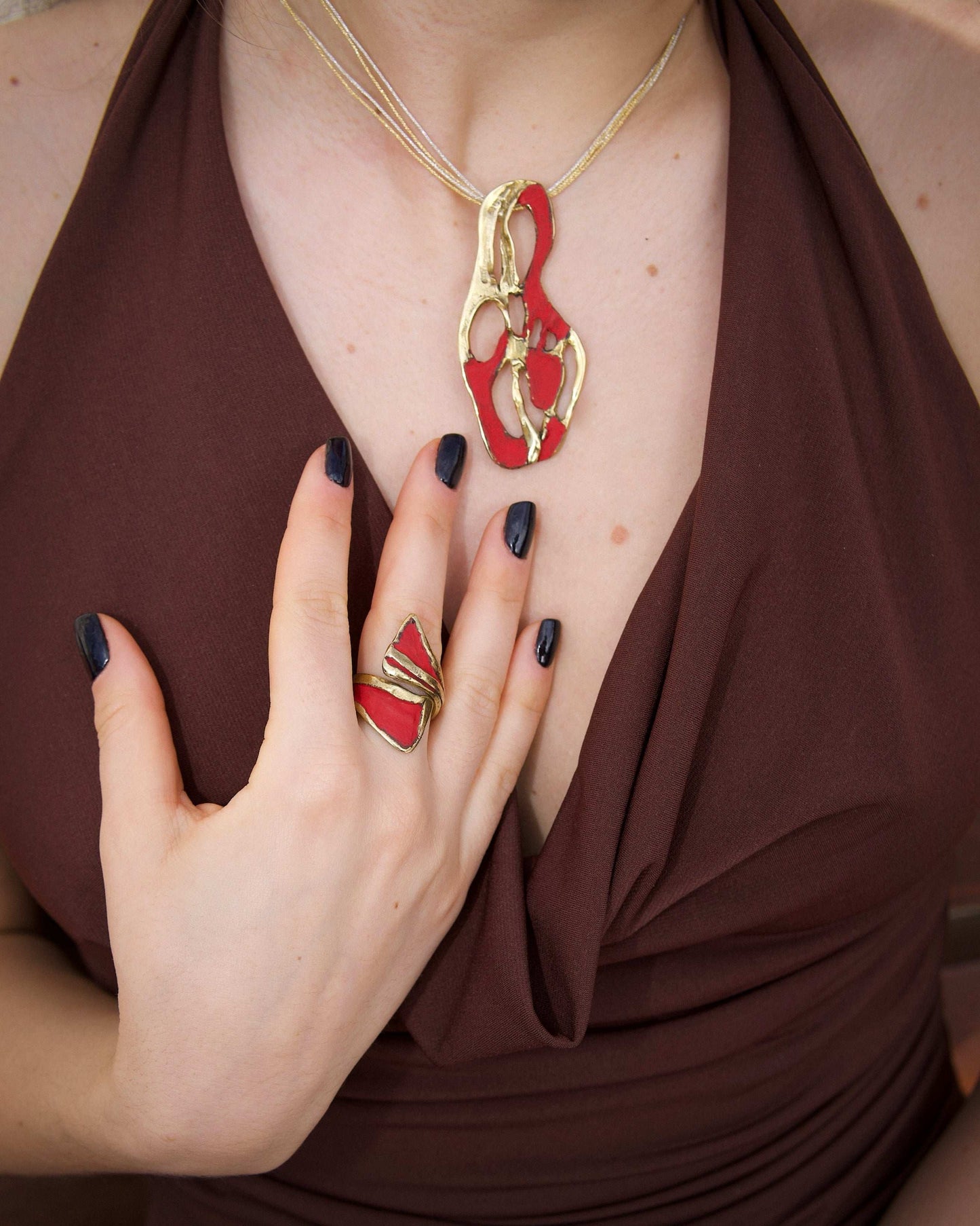 Gold dragon claw ring with red enamel on finger, open band