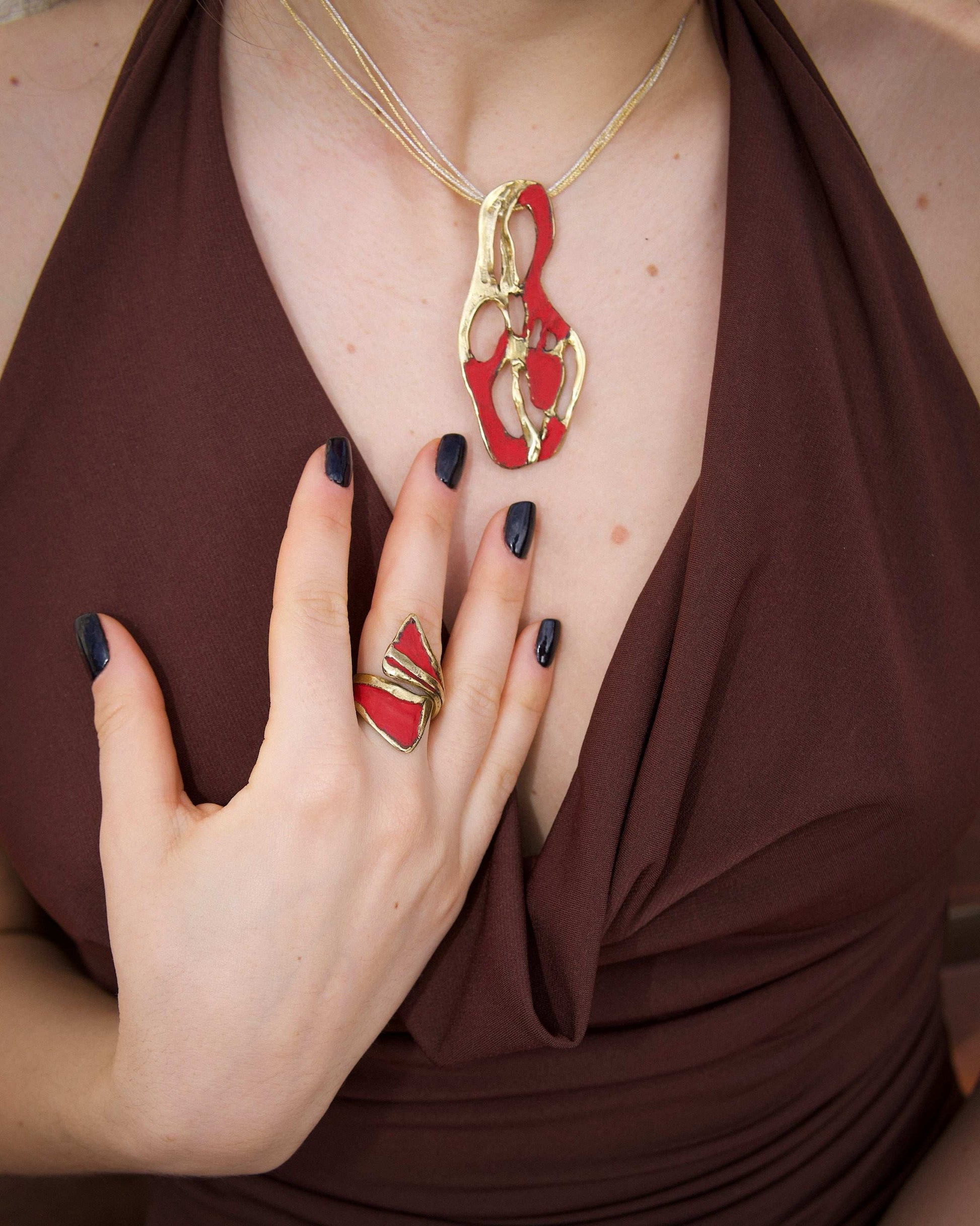 Gold dragon claw ring with red enamel on finger, open band