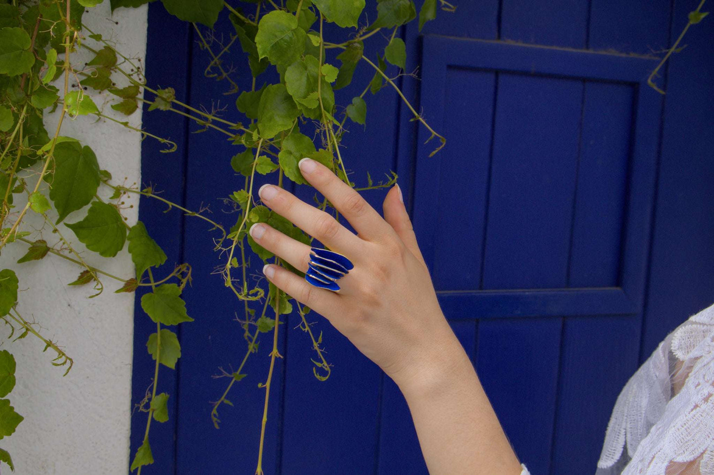 Gold-tone ring with blue inlay on hand