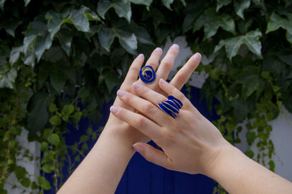 Gold-tone ring with blue spiral inlay on finger