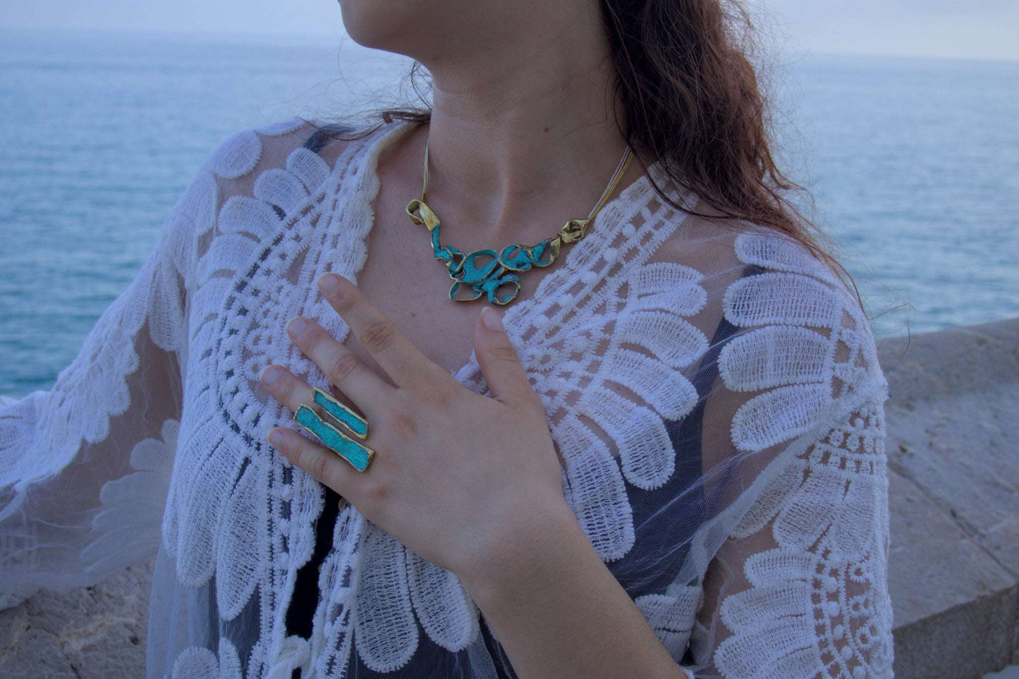 Turquoise enamel statement ring with gold-tone band, worn on finger