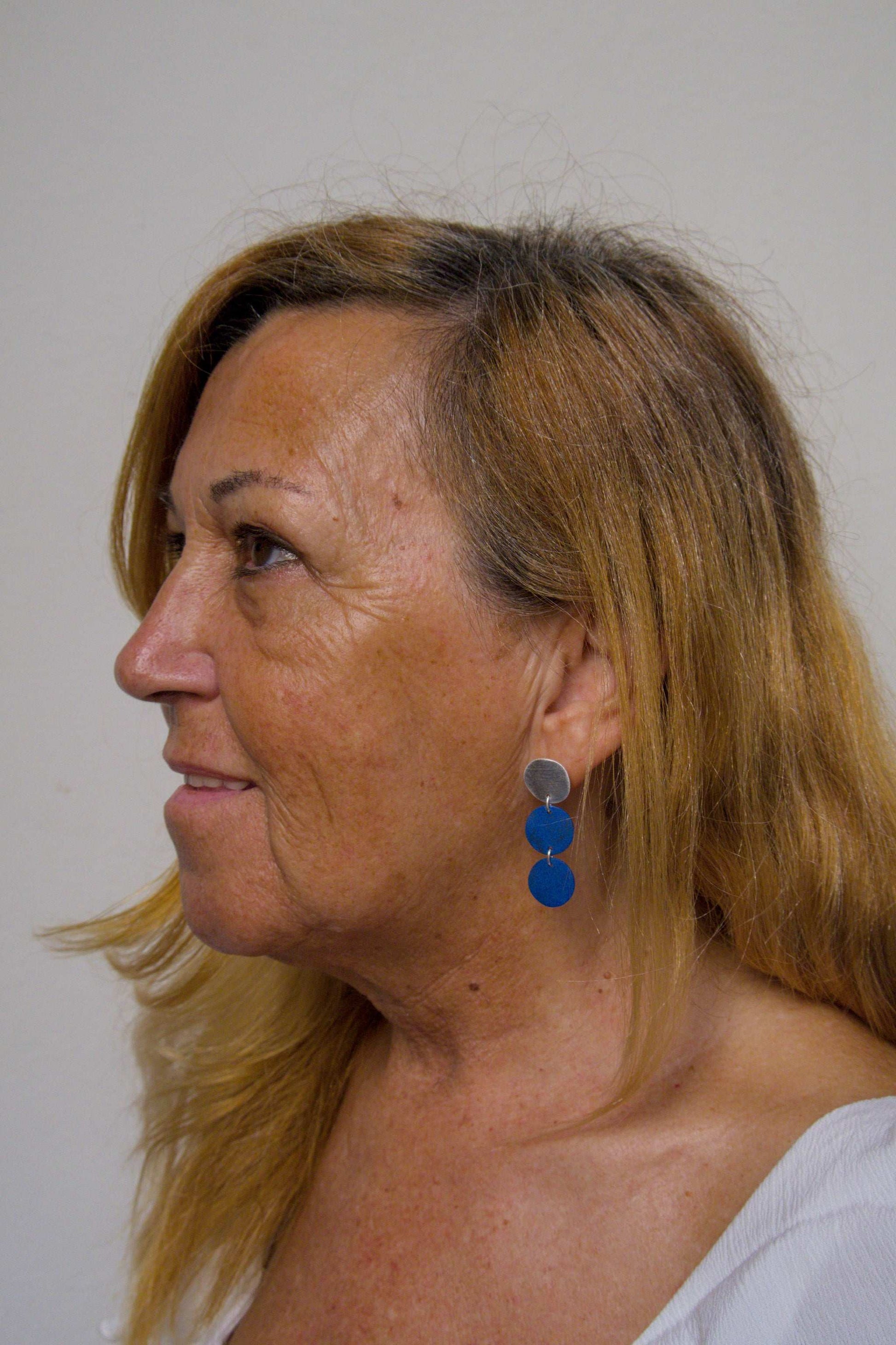 Three-disc motion earrings with silver-tone tops and two stacked blue disc drops