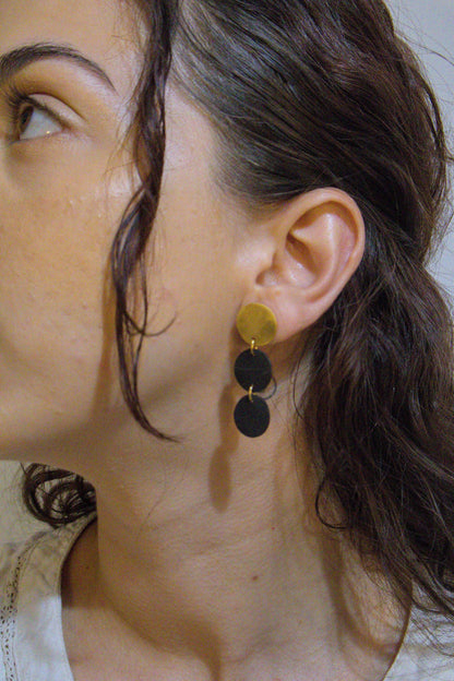Three-disc motion earrings with gold-tone top and two stacked black disc dangles