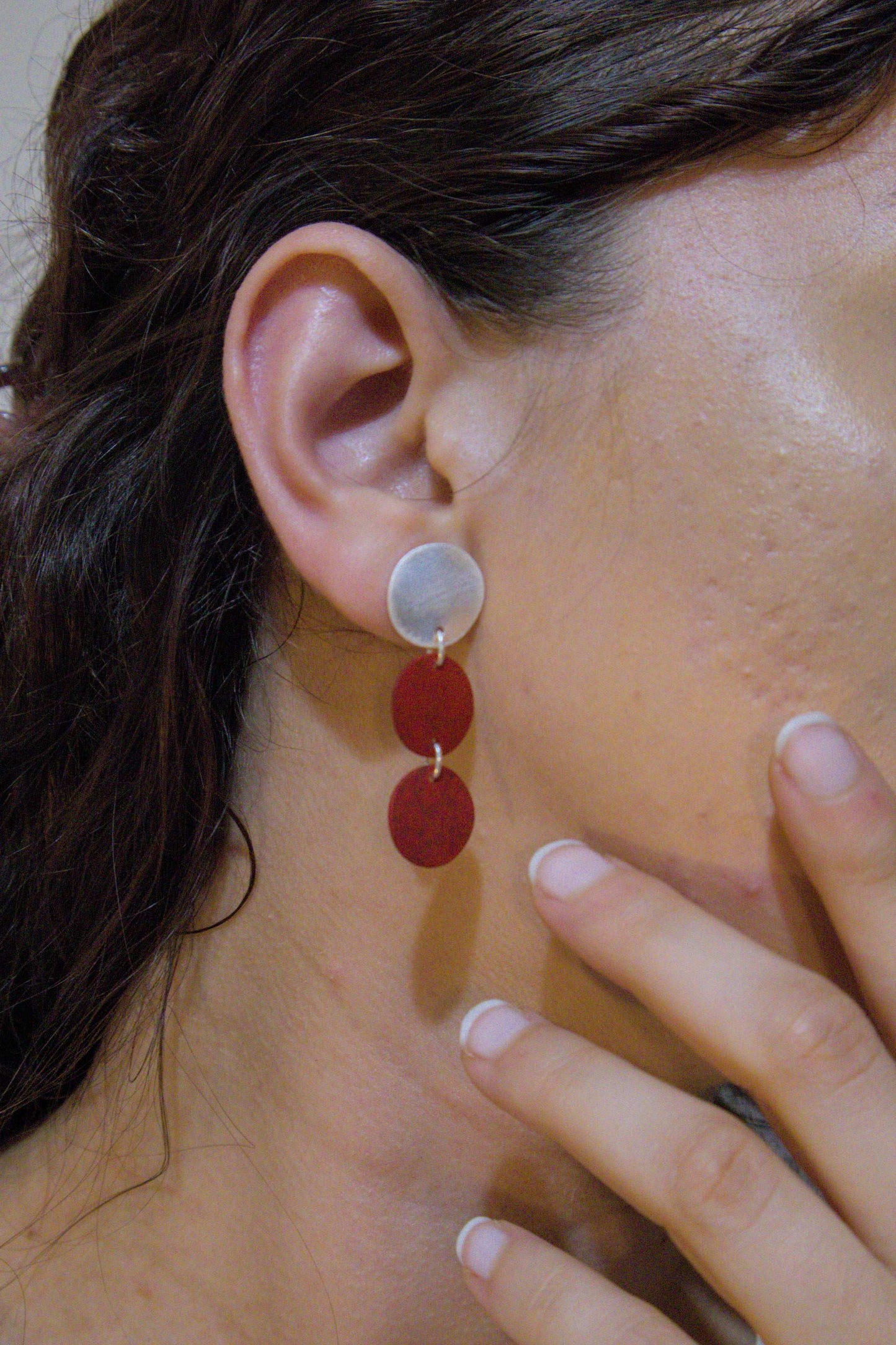 Three-disc motion earrings with light metal top and two stacked red discs