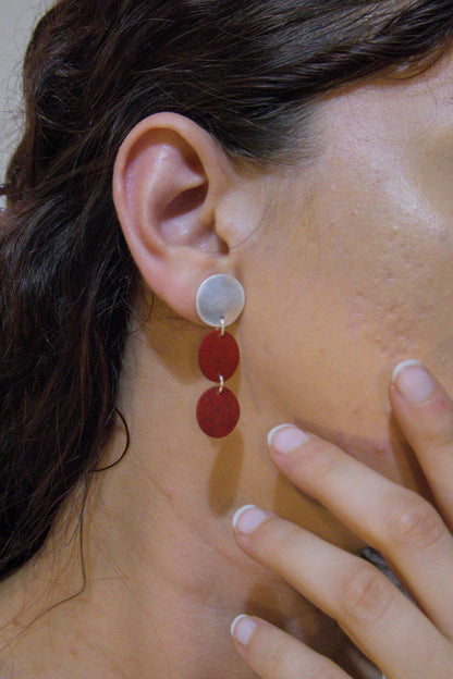 Three-disc motion earrings with light metal top and two stacked red discs