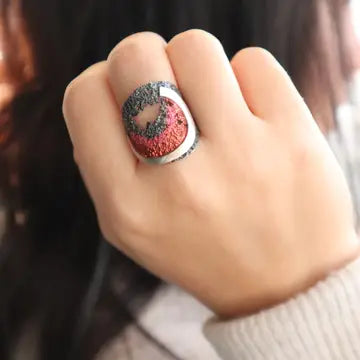 925 ring on finger with red-pink ocean swirl inset and speckled silver band