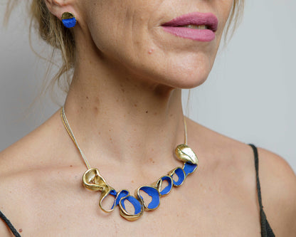 Gold-tone necklace with blue oval link beads and two shell charm drops