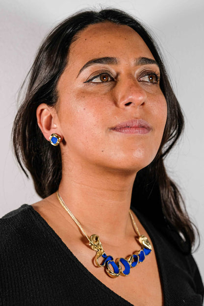 Gold-tone necklace with blue oval link beads and shell charm at the front