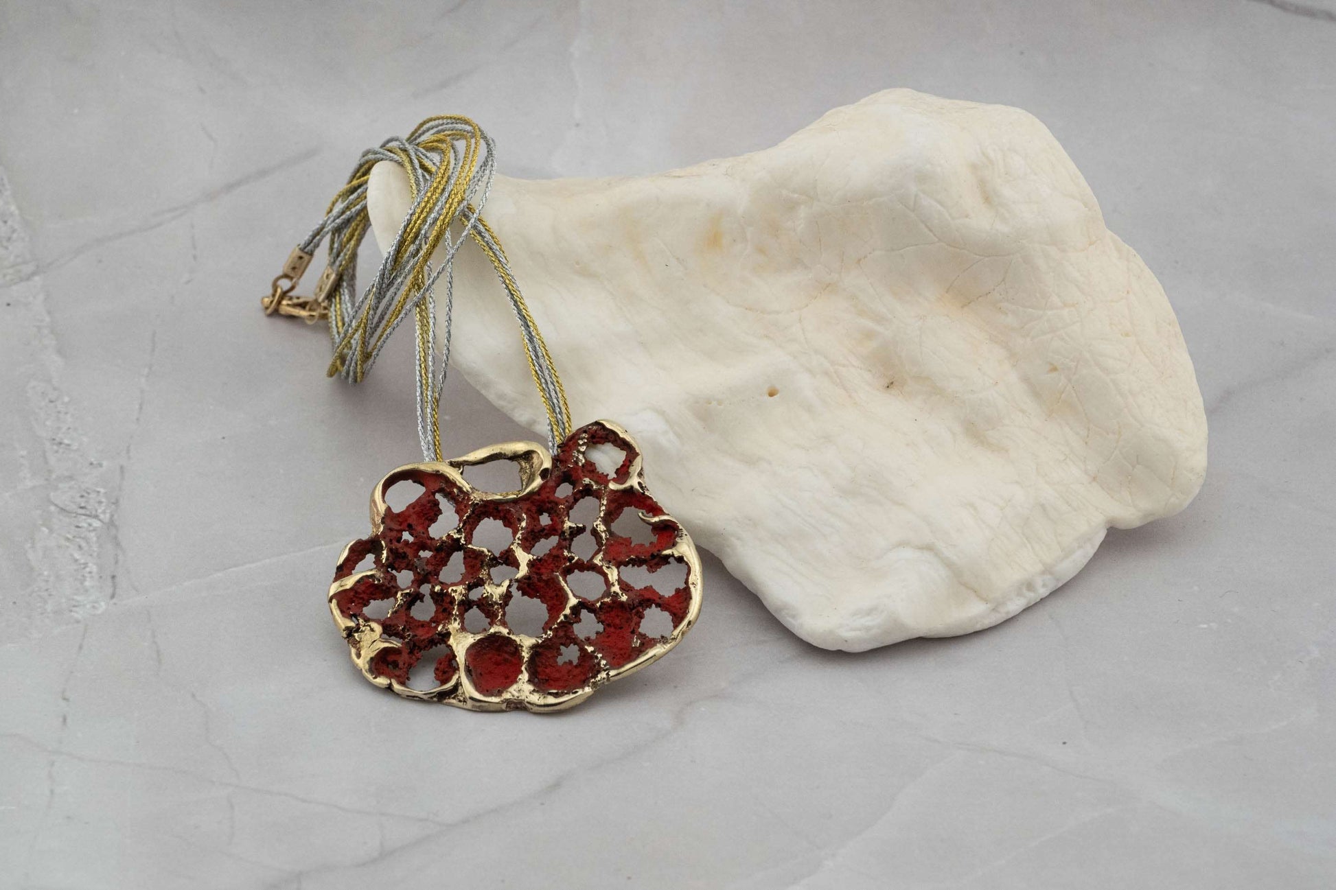 Perforata Lux pendant necklace, red perforated oval pendant with multi-strand cord