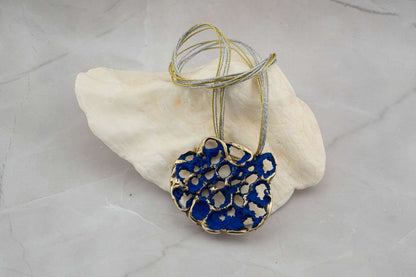 Perforata Lux pendant necklace, blue perforated oval pendant with multi-strand cord