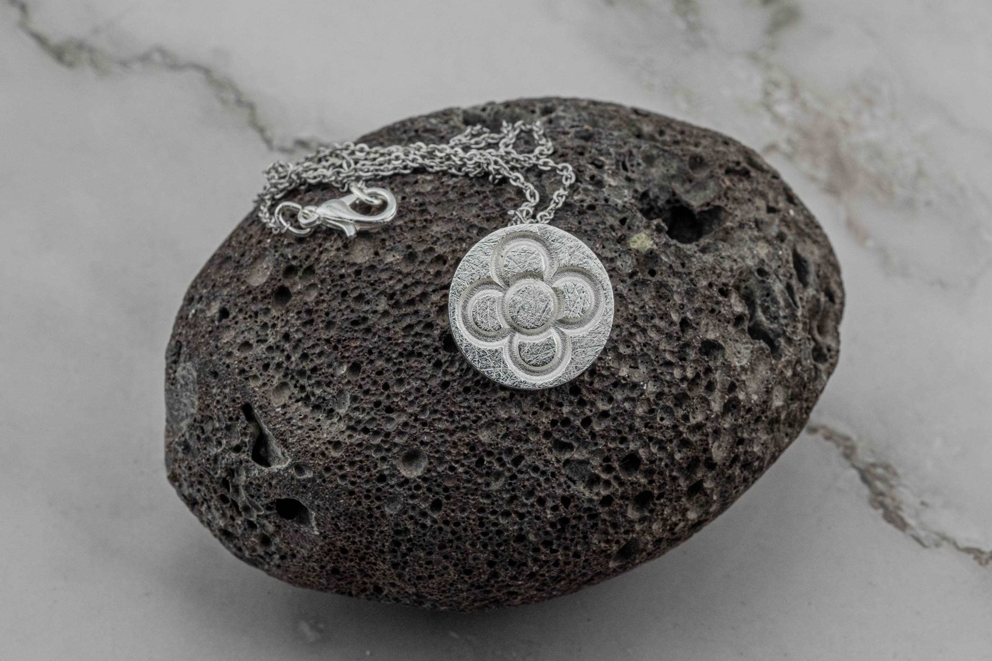 Silver round flower pendant on chain, round textured embossed flower motif