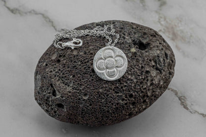 Silver round flower pendant on chain, round textured embossed flower motif