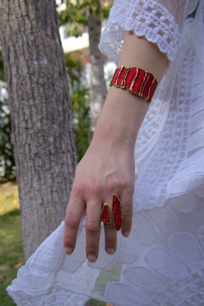 Red striped cuff bracelet with gold-tone border on a wrist