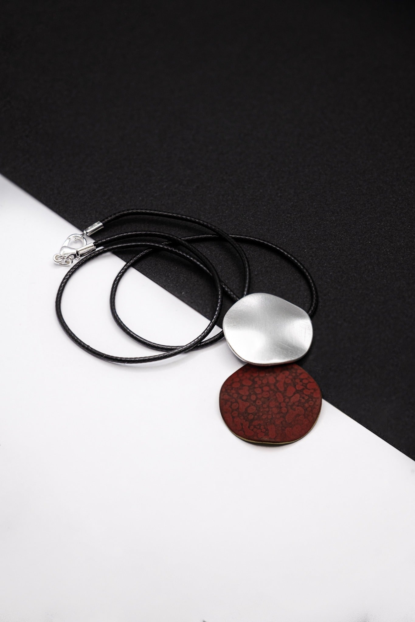 204 necklace with black cord, silver clasp, white and dark red textured round pendants