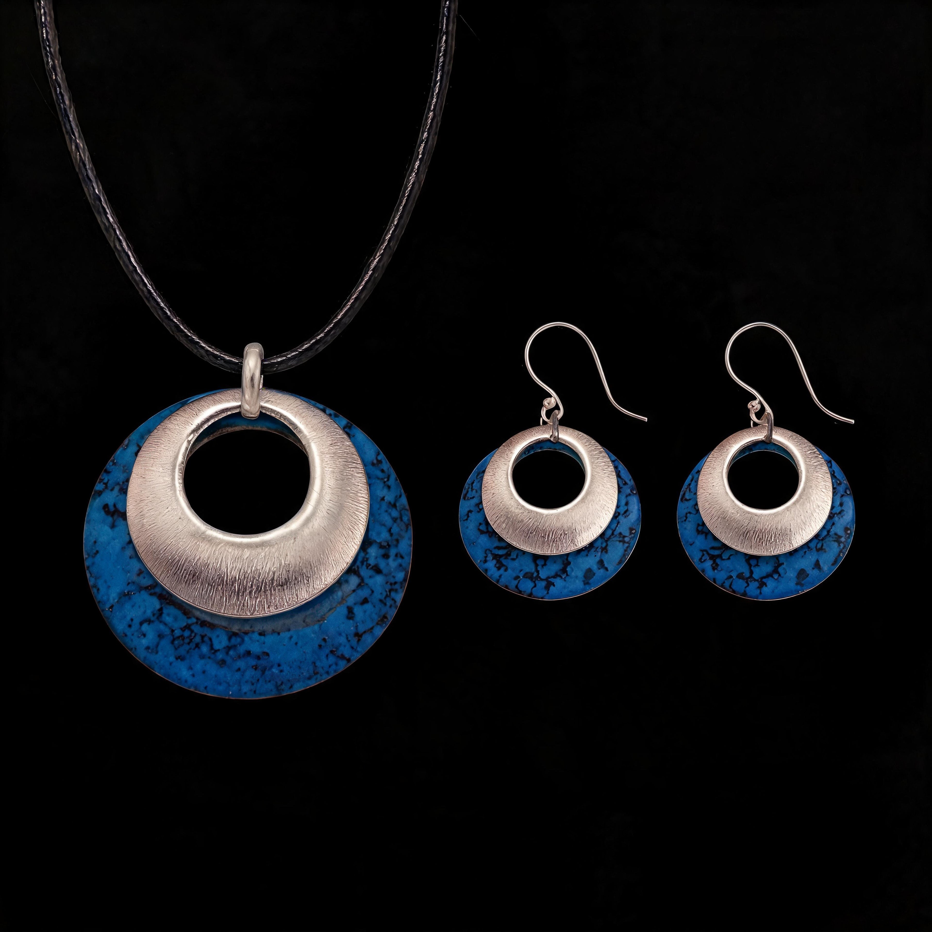 Silver-tone pendant and hoop earrings set with blue textured discs and black inner circles