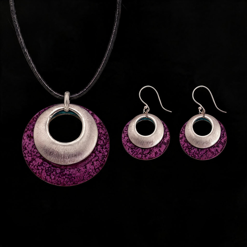 Silver-tone pendant and hoop earrings set with purple textured discs and black inner circles