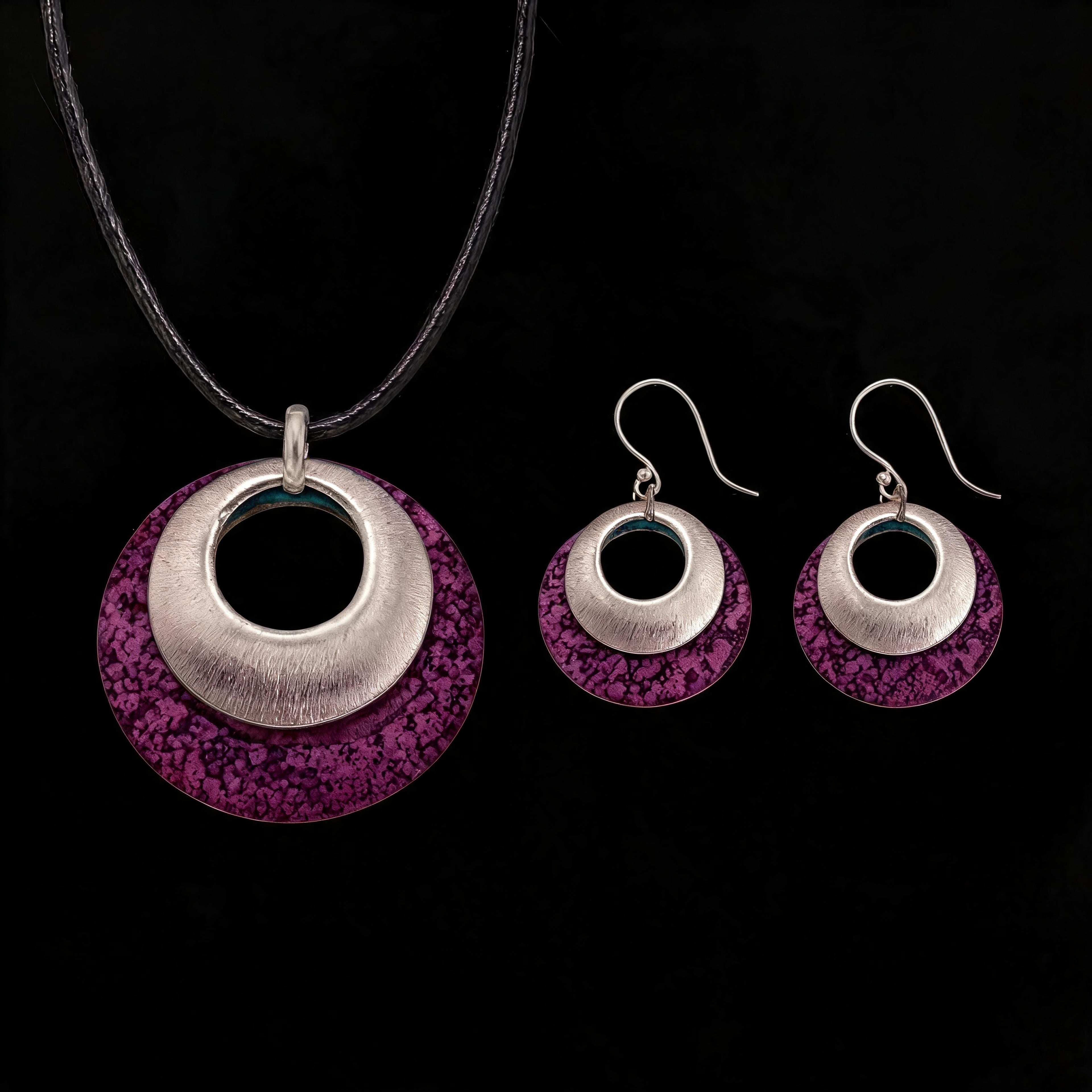 Silver-tone pendant and hoop earrings set with purple textured discs and black inner circles