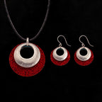 Silver-tone pendant and hoop earrings set with red textured discs and black inner circles