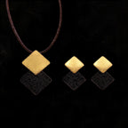 Gold-tone necklace with three stacked diamond charms: brushed gold and dark speckled enamel