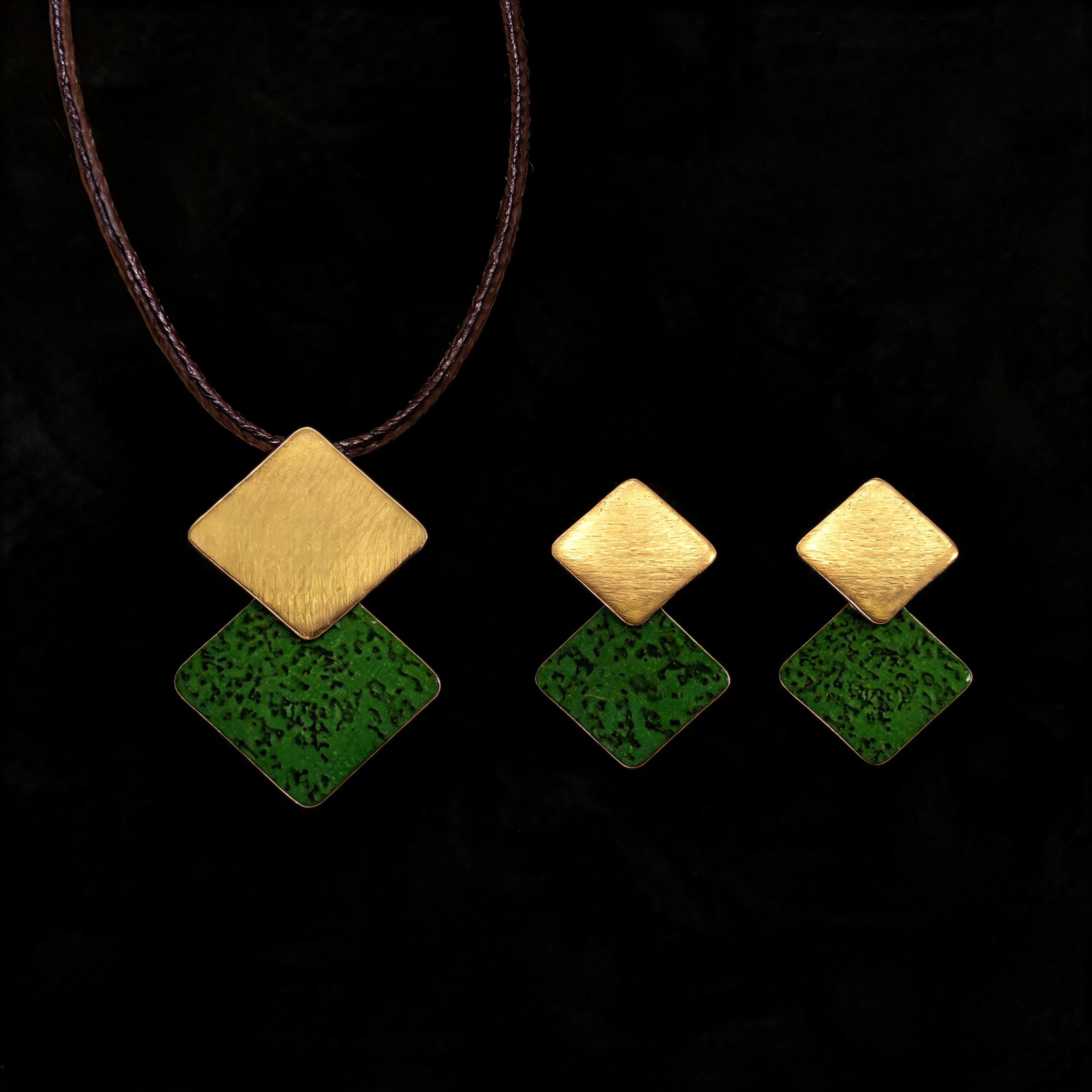 Gold-tone necklace with three stacked diamond charms: brushed gold and green enamel