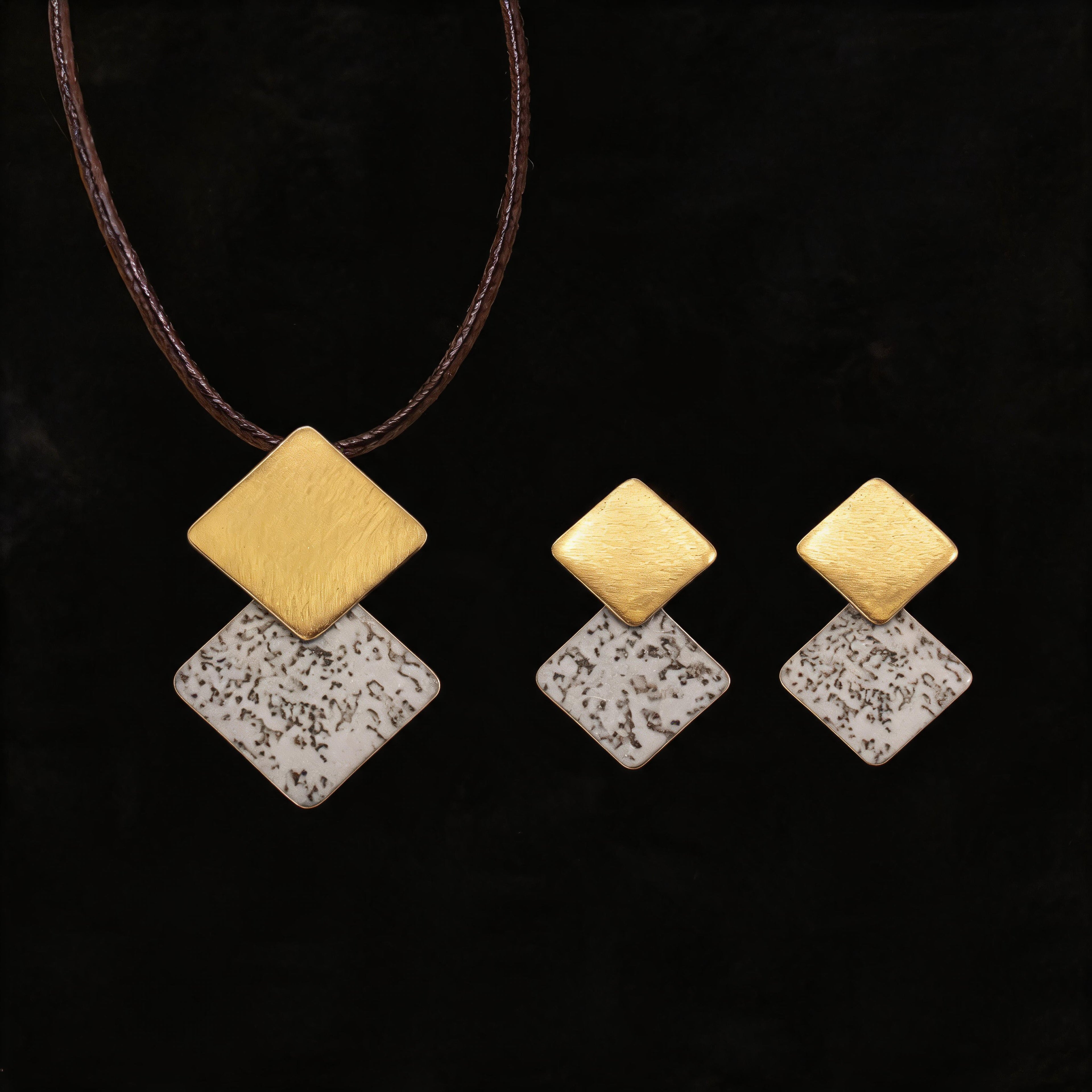 Gold-tone necklace with three stacked diamond charms: brushed gold and speckled white enamel