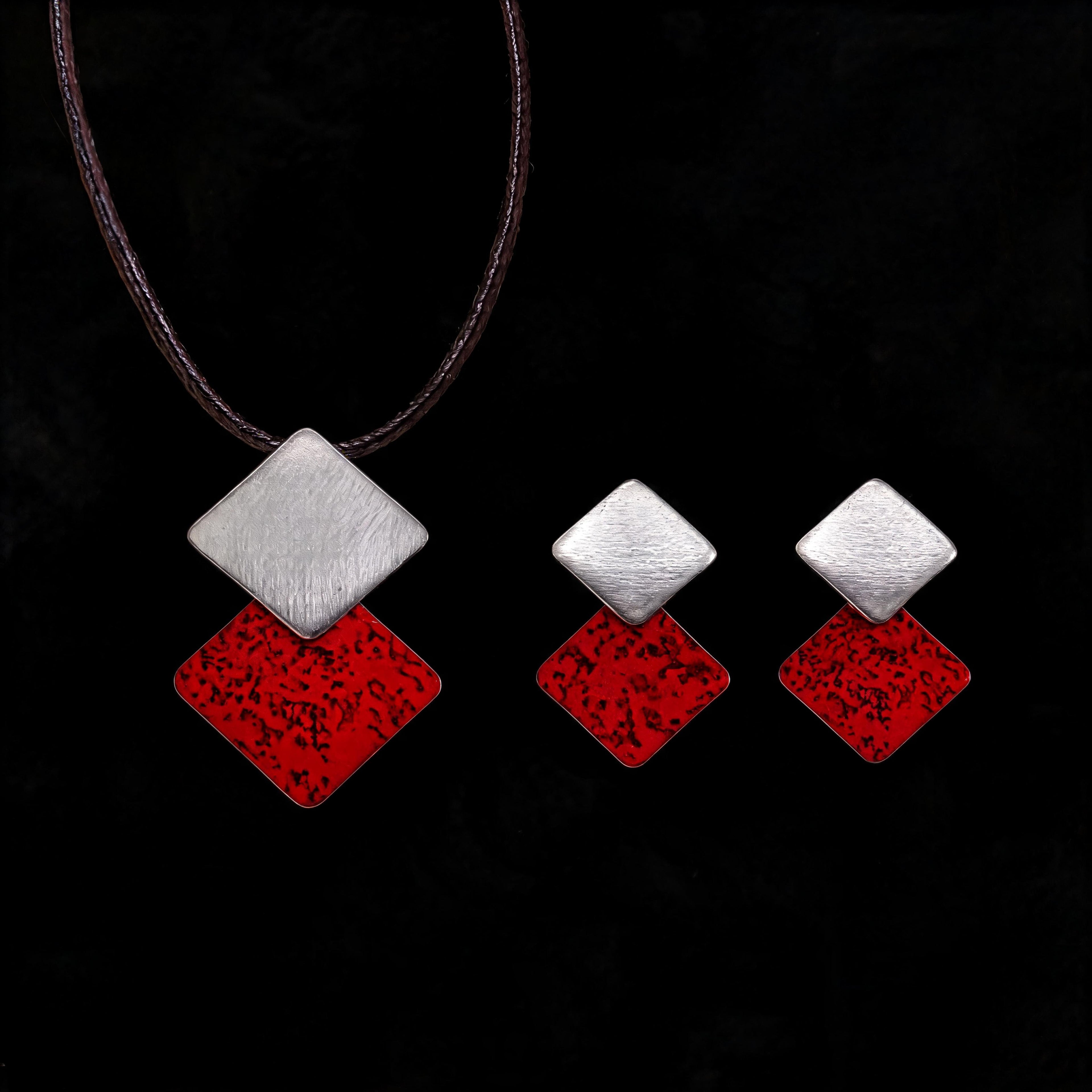 Silver-tone necklace with three stacked diamond charms: brushed silver and red enamel