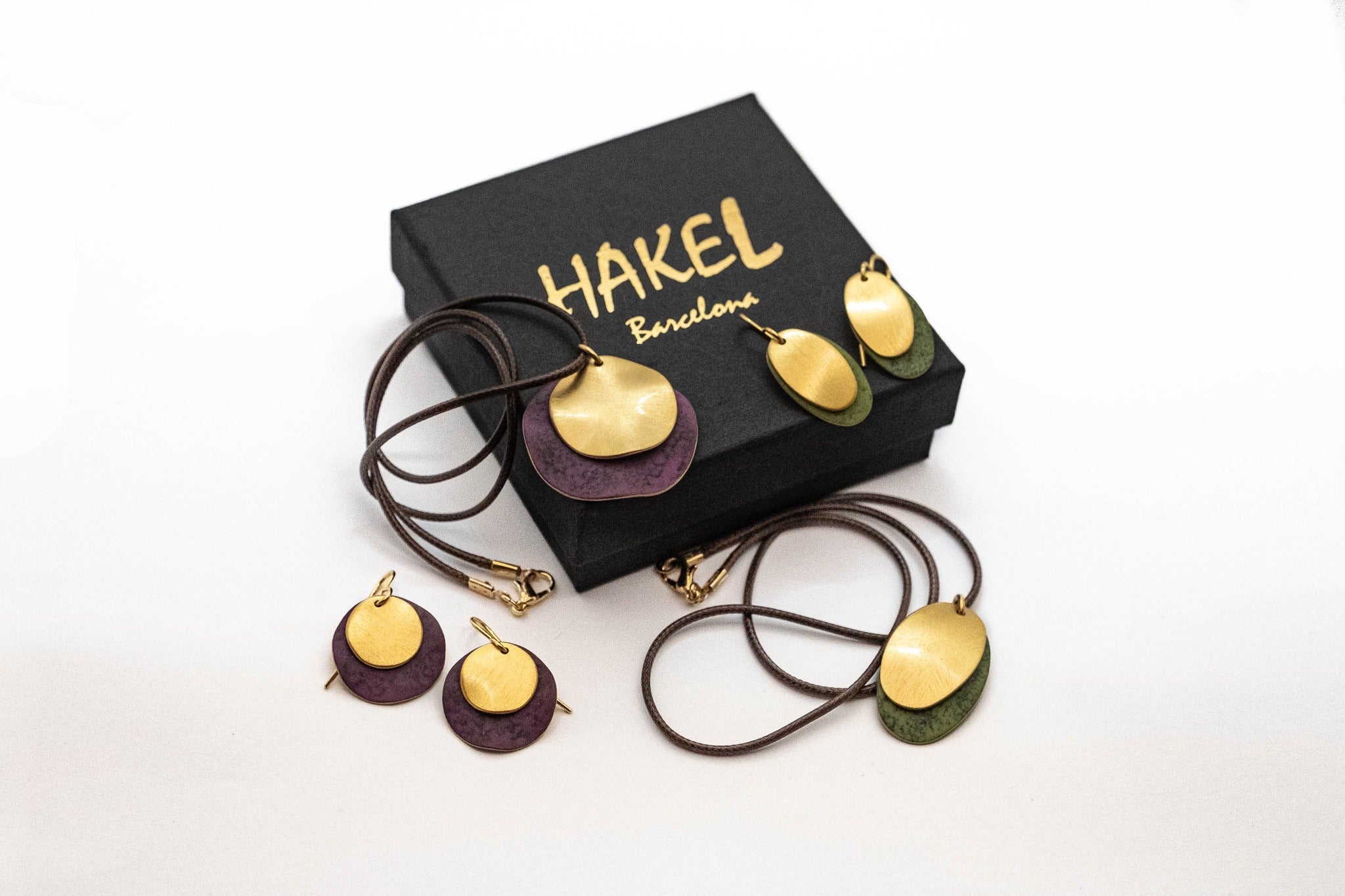 Gold-tone drop earrings with round purple and green disc charms on curved hooks