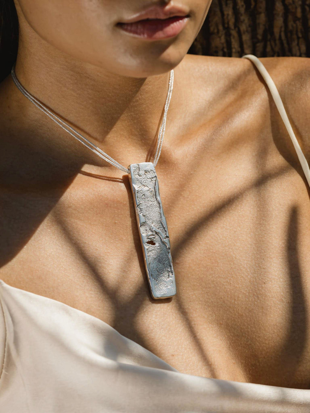 Collaret de plata Strata portat al coll amb penjoll rectangular martellejat