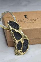 Gold-tone necklace pendant with three dark oval inlays on cord
