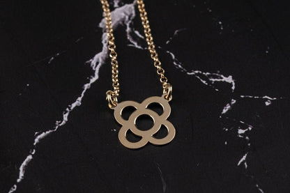 Gold flower pendant necklace with link chain and petal-shaped circular charm.