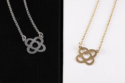 Silver flower pendant necklace with link chain and circular petal-shaped charm.