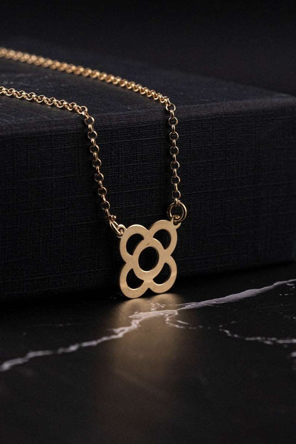 Gold flower pendant necklace with link chain and petal-shaped circular charm.
